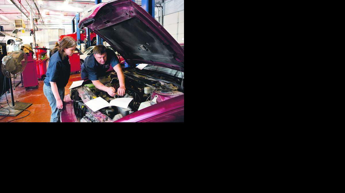 
Kansas City Kansas Community College Automotive Technology Associate Professor John Hattok worked on a car with Karen Rohrer, one of his students.
