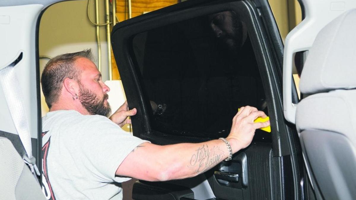 File photo. A professional tints windows at a Kansas City area auto shop.