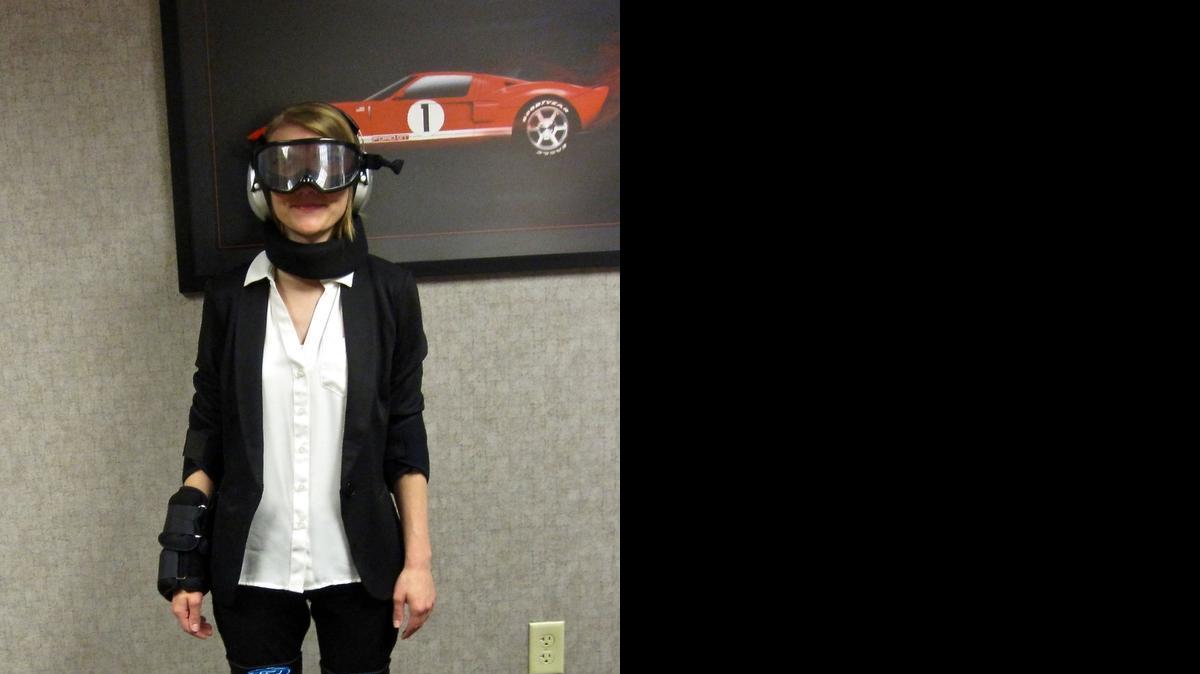 
Ford spokesperson Christine Schick demonstrates what the impairment suit simulator looks like when it is worn.
