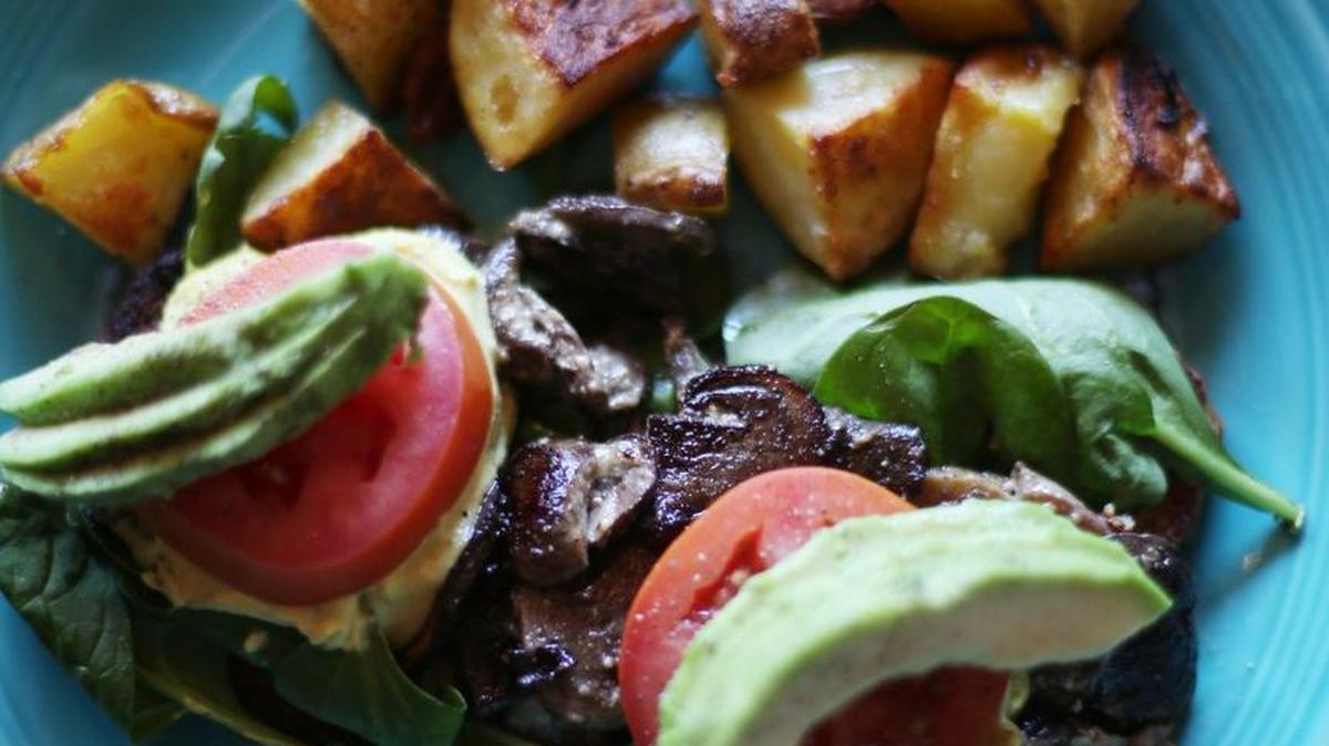 The I Am Blessed entree at Cafe Gratitude includes marinated mushrooms, spinach, tomatoes and cashew hollandaise sauce on gluten-free bread, served with a side of breakfast potatoes. It sells for $10.50.