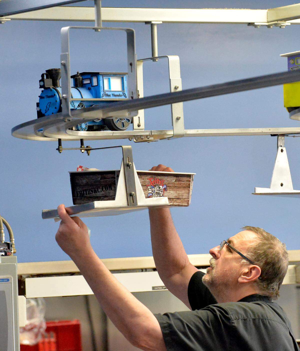Anthony “Tony” Hochniuk, general manager of Fritz’s Railroad Restautant in Shawnee, places a boxed order on a tray delivered by a toy train. Founder Fred F. “Fritz” Kropf invented the Skat Kat system in the 1970s.