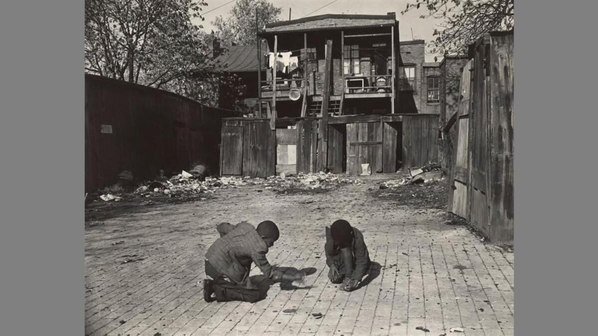 In this Gordon Parks photo, two young boys shoot marbles in front of their home in November 1942. The exhibit “Gordon Parks: The New Tide, Early Work 1940-1950” is on display at the National Gallery of Art in Washington, D.C., through Feb. 18.