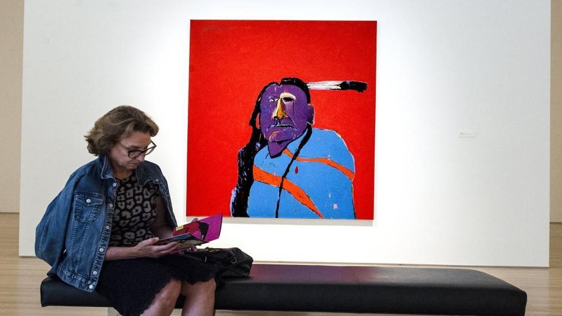 Kim Fiss was among the viewers at the opening reception for “Super Indian,” which features the work of Fritz Scholder, at the Nerman Museum of Contemporary Art in Overland Park. Scholder’s “American Portrait With One Eye” at the front of the gallery opens the show.