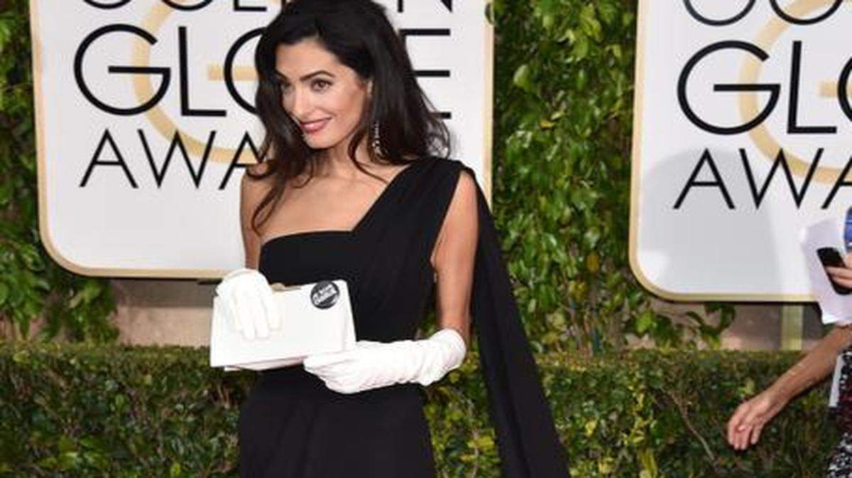 
BIG DEBUT
The fashion World gasped when Amal Clooney stepped onto the red carpet for her first big Hollywood event, wearing a black haute-couture Dior gown and long, white gloves.  She told Ryan Seacrest on the red carpet that “the gloves are just my own.” Joked new hubby George (who won a lifetime achievement award): “She sewed them just this morning.” We don’t know what George was wearing. But really, who cares now?


