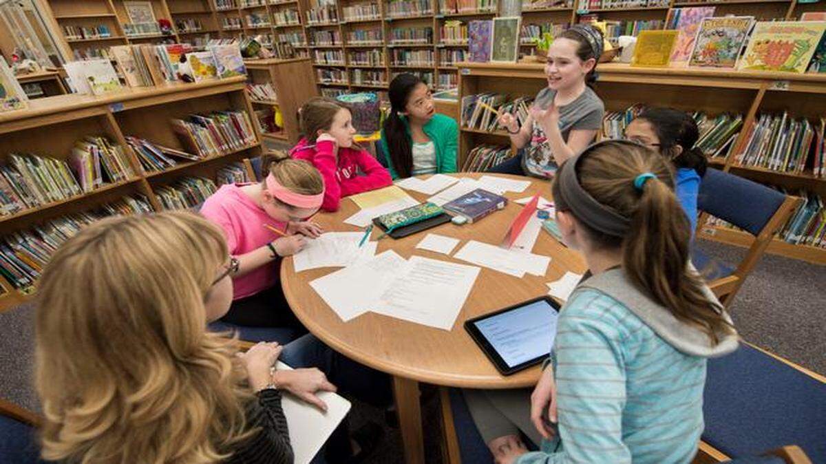 
Standing to make her point, fifth-grader Kenna Finlason discusses a Newbery book award selection at the Brookwood Elementary library in Leawood.
