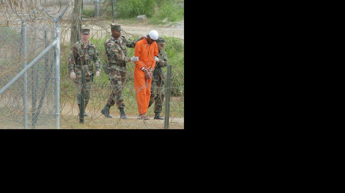 
As of January, 122 prisoners remained at Camp X-Ray at the U.S. Naval Base at Guantanamo Bay, Cuba. A detainee was led to interrogation in a 2002 photo. 
