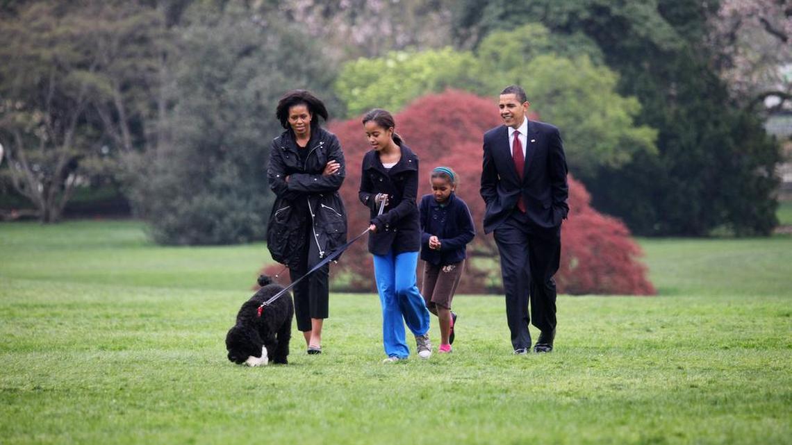 Former first lady Michelle Obama, left, President Barack Obama, right, and their children Malia and Sasha, walk with their dog Bo at the White House in 2009. Michelle Obama’s memoir will be released Nov. 13.