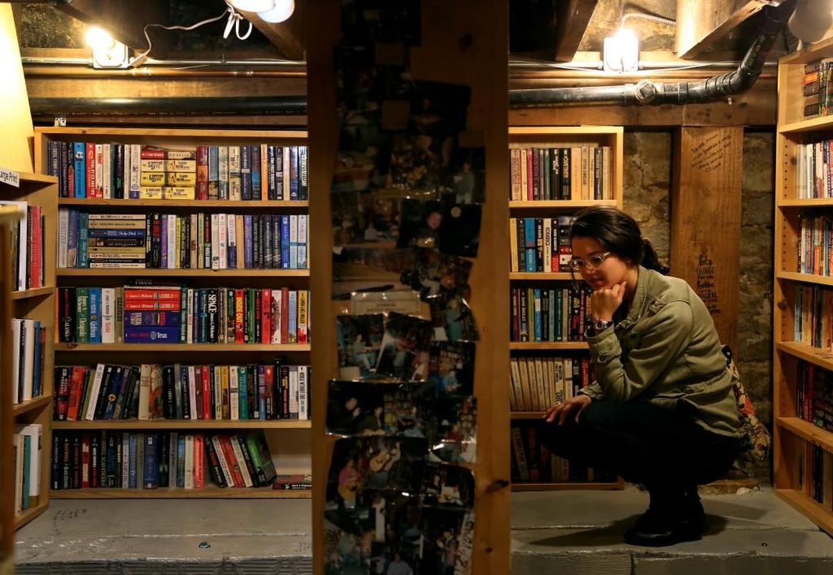 Samantha Gibbs browses in the basement of Prospero’s Books, a favorite for bibliophiles who love to look through the diverse collection or tuck away in one of the shop’s many nooks to read.