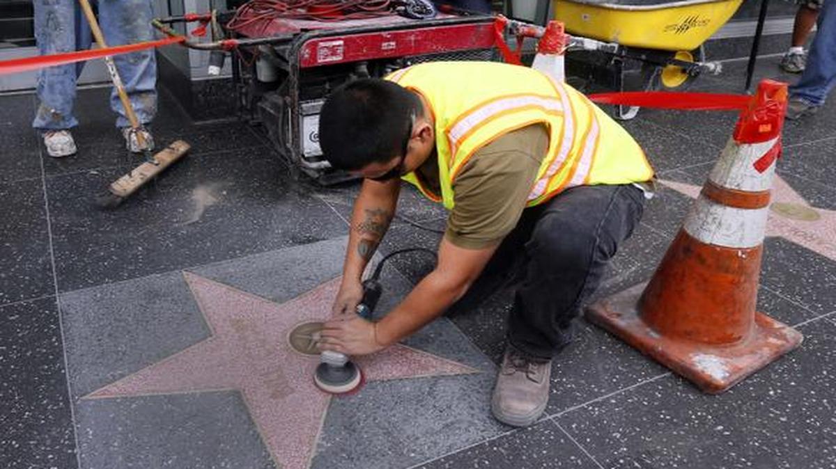 
A work crew cleans graffiti off the Bill Cosby star on the Hollywood Walk of Fame
