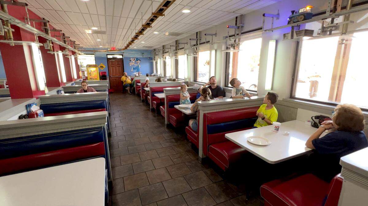 Diners at Fritz’s in Shawnee watch as an order makes its way to a table on a train delivery system.