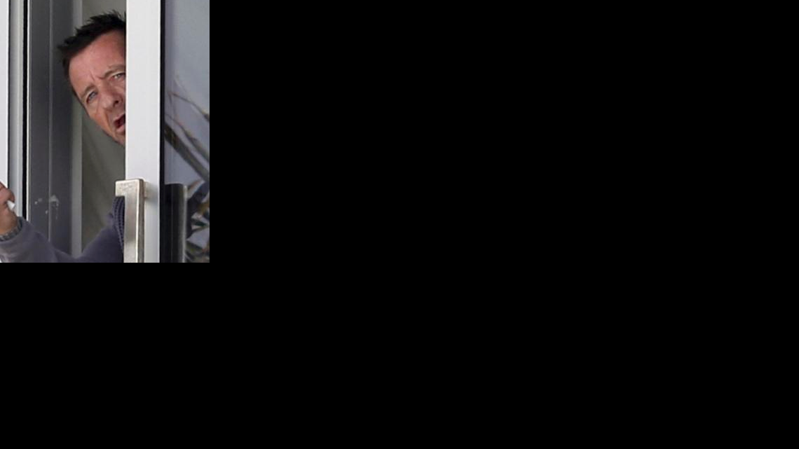 
Phil Rudd, drummer for the rock band AC/DC, gestures from a window at his house in Tauranga, New Zealand
