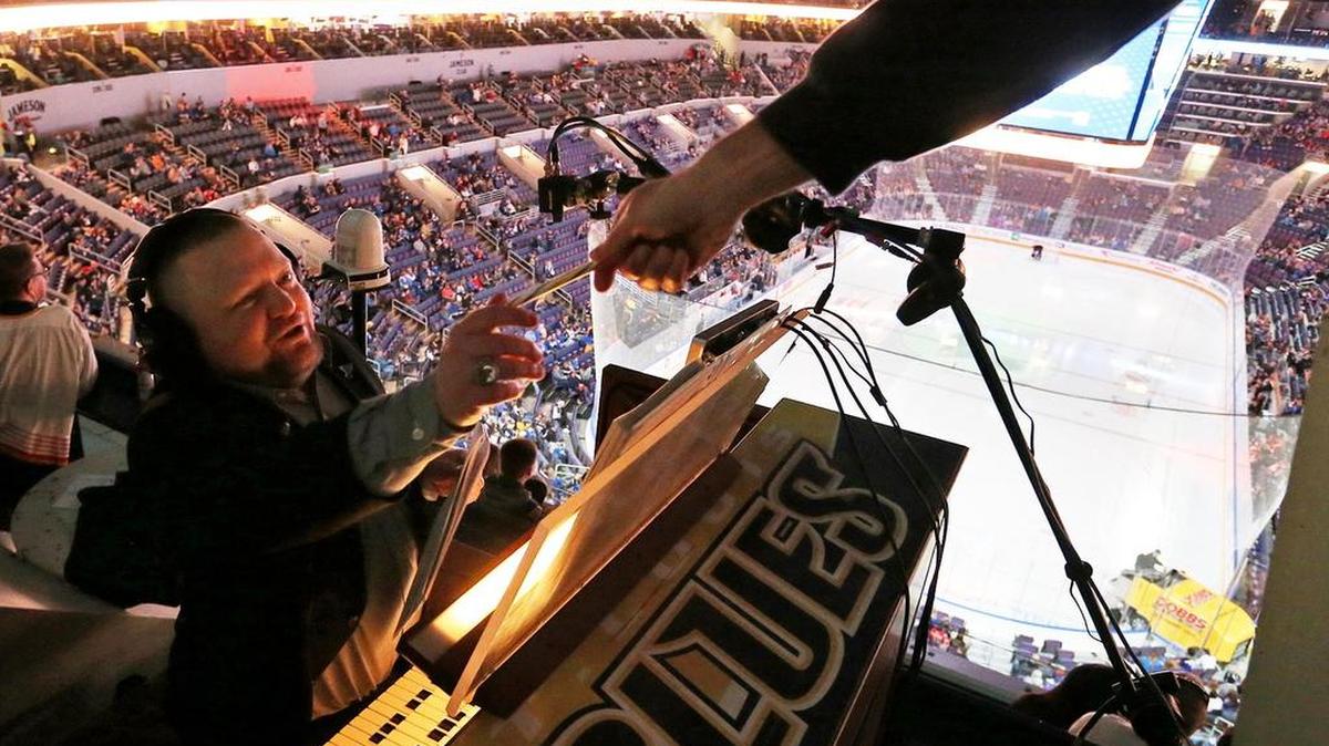 A fan hands organist Jeremy Boyer a candy cane at the Enterprise Center before the St. Louis Blues game against the Calgary Flames.