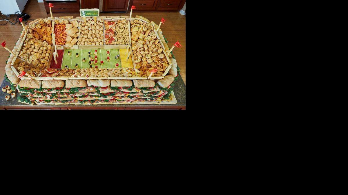 
This “snackadium,” features sub sandwiches, salsa, guacamole and cheese dip among pizza slices and other snacks. 
