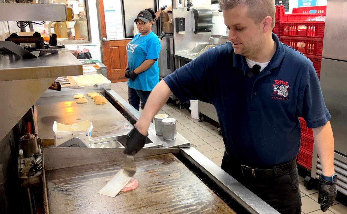 Fred Kropf, the son of owners Fred and Mary Kropf and operations manager for the restaurants, grills a hamburger patty for the Gen Dare.