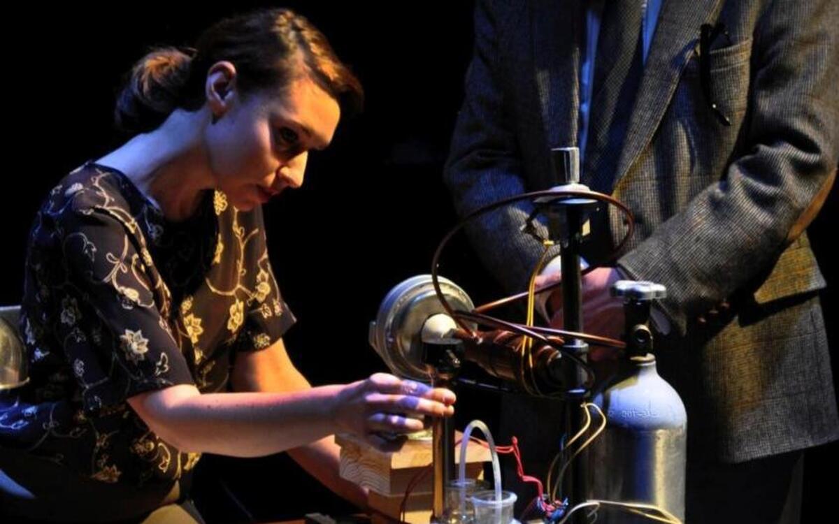In the Metropolitan Ensemble Theatre’s production of “Photograph 51,” scientist Rosalind Franklin (Amy Attaway) meets with sexism and derision from her co-worker (Robert Gibby Brand).