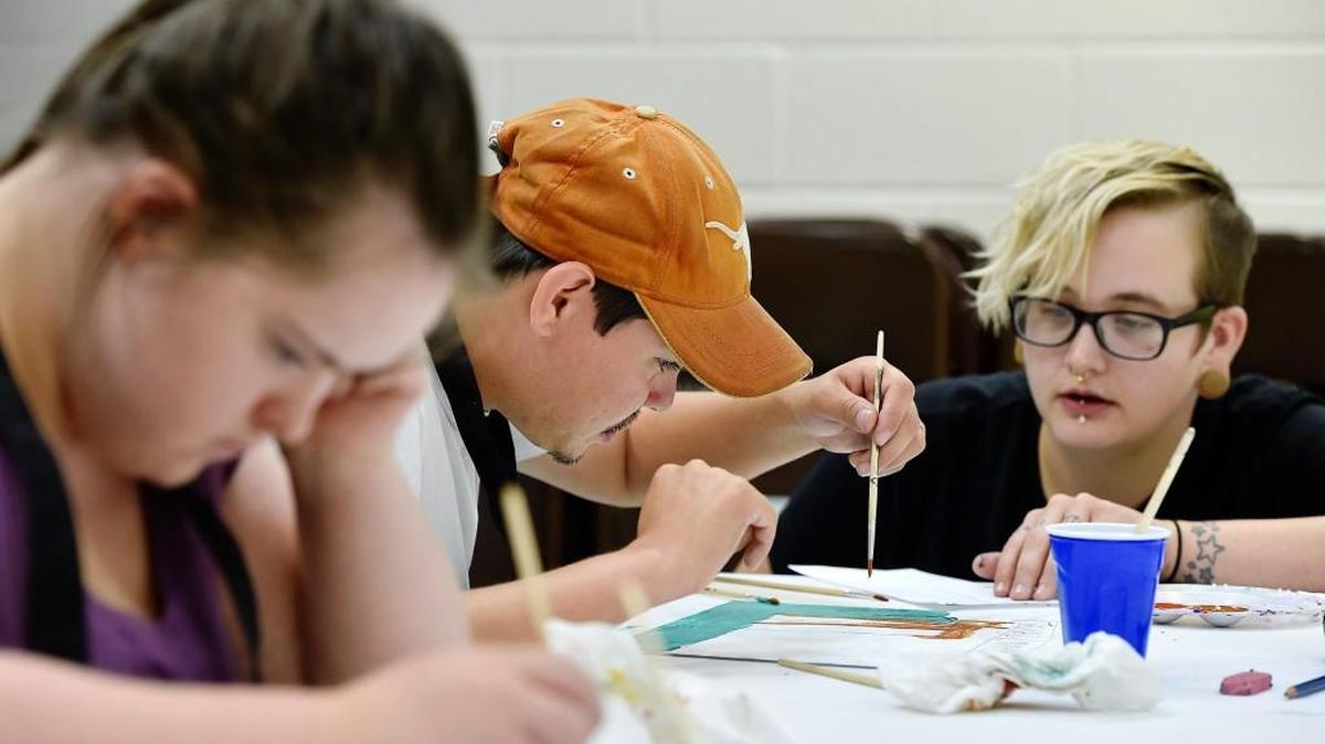 
Jessica Hayes (right), an art instructor with the Mission Project 2’s art enrichment program, works with participants on paintings for this First Friday show at the Boveri Realty Group Art Space. MP2 helps adults with developmental or intellectual disabilities to live independently.
