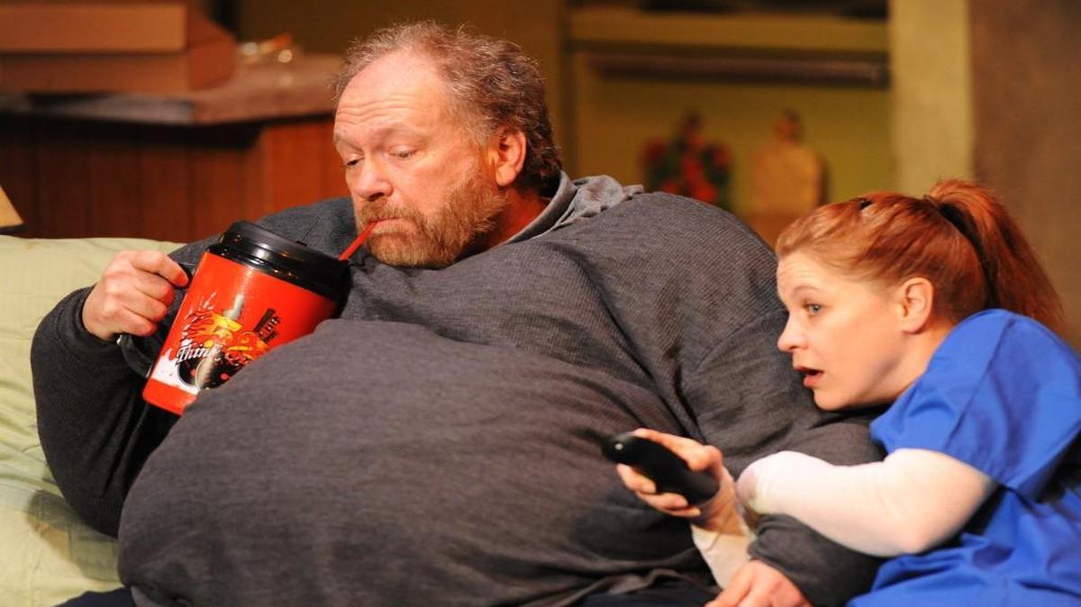 Liz (Cinnamon Schultz) watches junk TV with Charlie (Phil Fiorini) in “The Whale.”