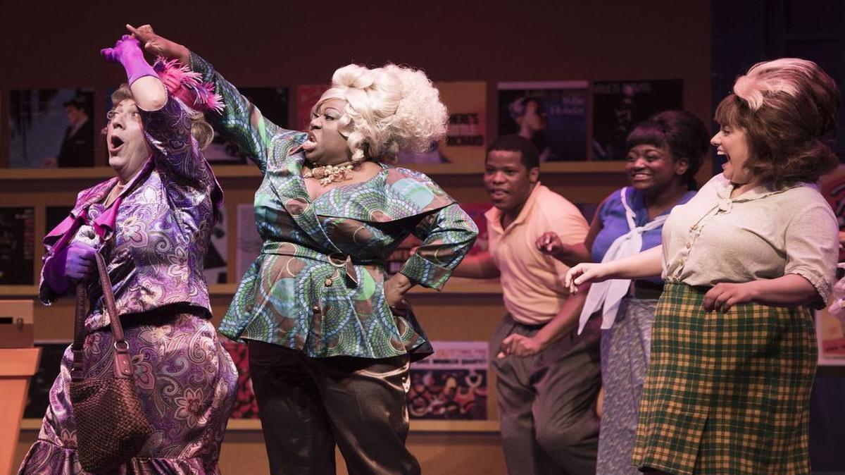 
Jim Korinke as Edna Turnblad (left) gets twirled by Motormouth Maybelle (Melody Betts) as Tracy Turnblad (Lena Mary Amato, right) in “Hairspray” at the New Theatre Restaurant.
