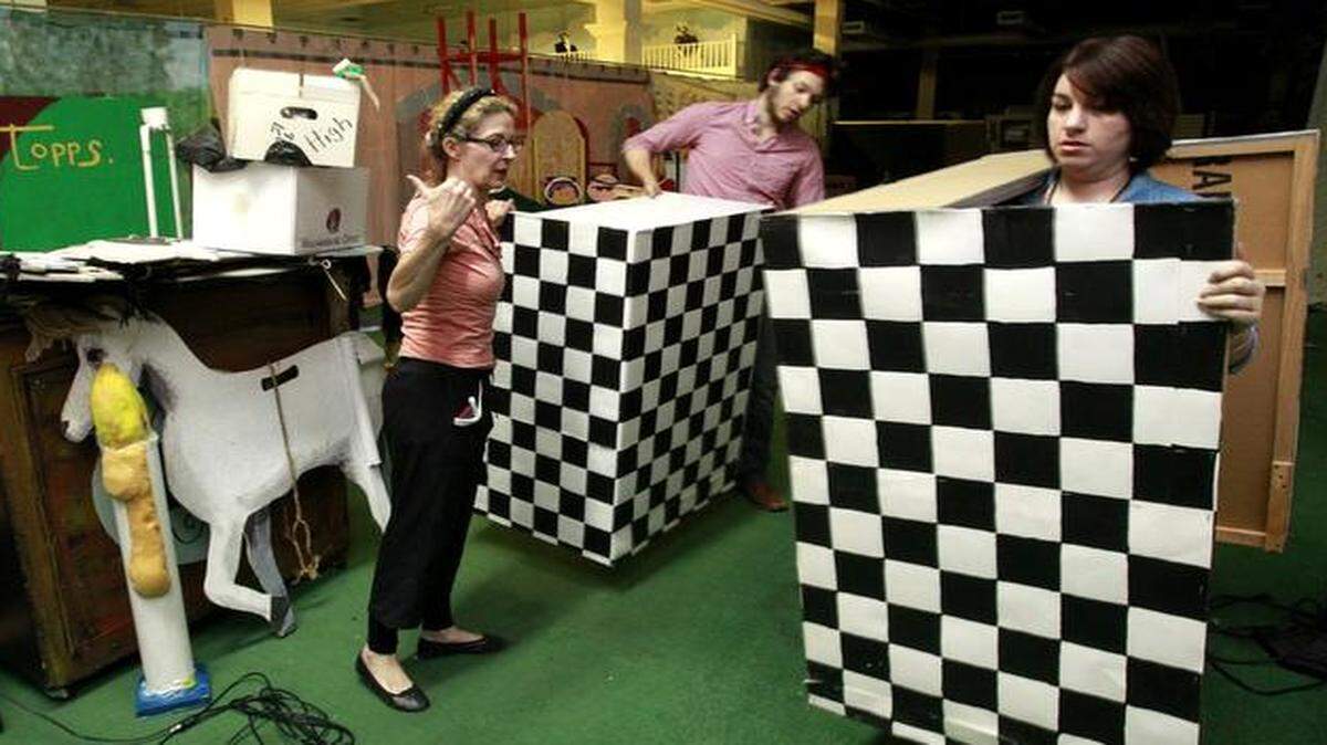 
Since the Martin City Melodrama soon will be moving out of Metcalf South Shopping Center, the theater group is preparing for a garage sale of sorts. On Friday, Jeanne Beechwood (left) directed Cody Goeppner and Samantha Barboza where to take some of the scenery in the sale area.
