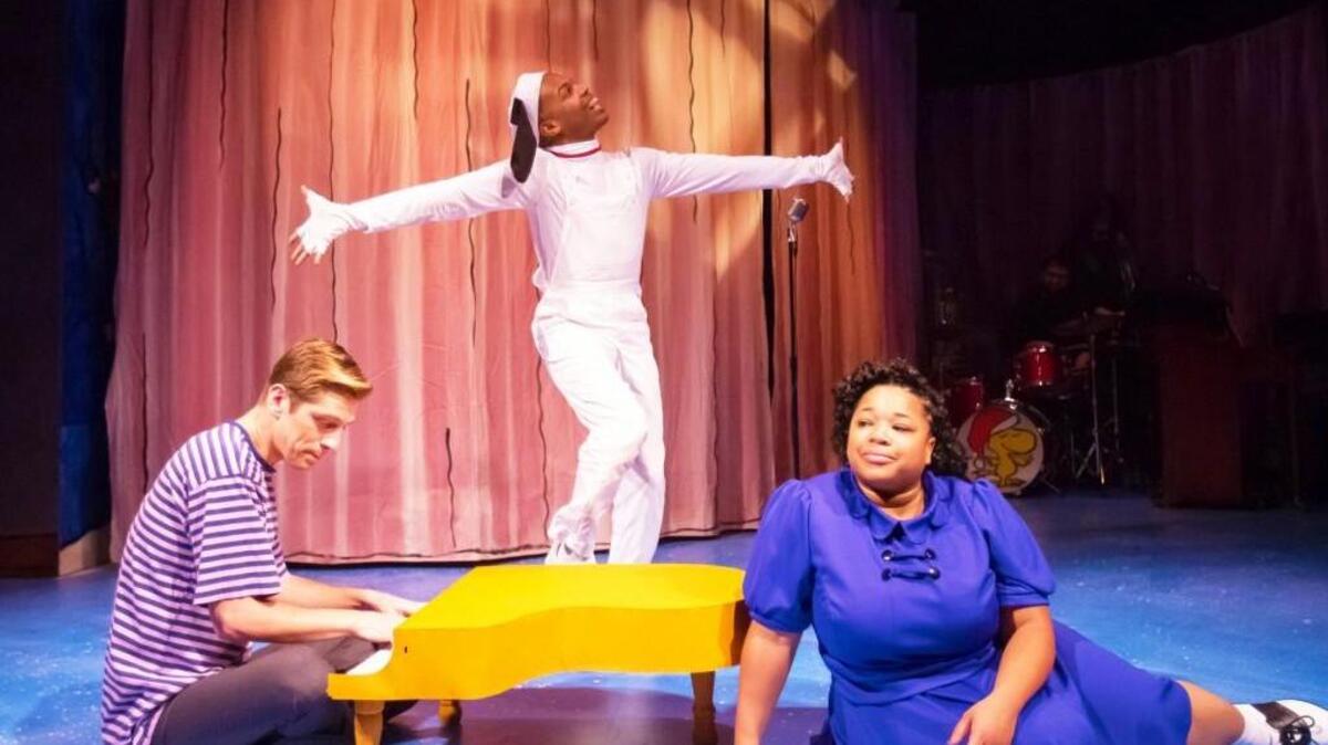 Vincent Wagner (as Schroeder), Evan J. Lovelace (as Snoopy), and Shon Ruffin (as Lucy) star in “A Charlie Brown Christmas,” based on the television special, playing live on stage at The Coterie.