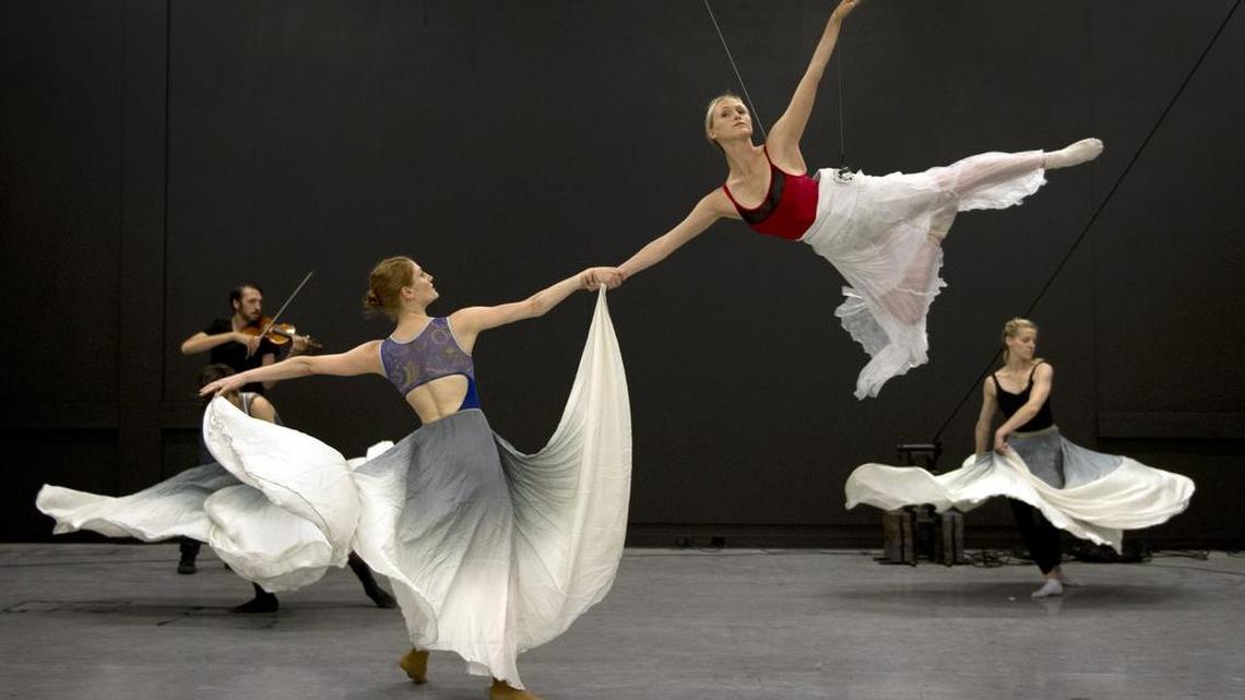 
During rehearsals for their “Gravity of Center” performance, Quixotic dancer Beau Campbell sailed through the air while being held by Laura Jones Wallner. Shane Borth accompanied on violin, while Christen Edwards (right) danced in the background. Quixotic performed the work Saturday at the Lied Center in Lawrence. 
