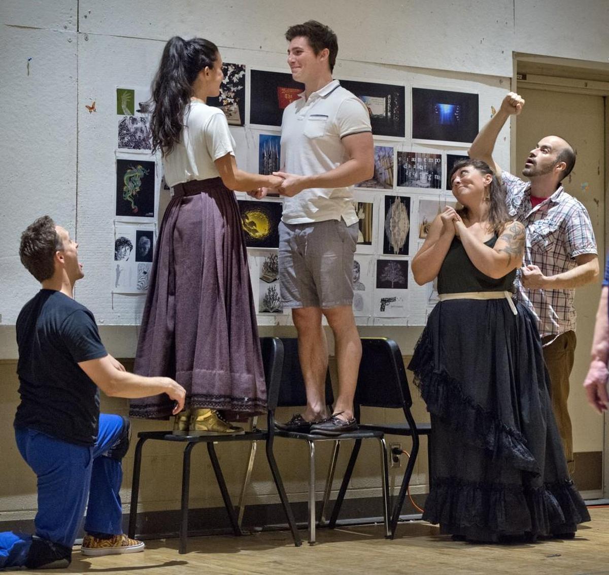 In Kansas City Repertory Theatre’s “Between the Lines,” Curt Hansen (standing on chair) plays Prince Oliver, who has magically appeared from a storybook. With him during a recent rehearsal were Daniel Gardner (from left), Emily Shackelford, Shanna Jones and Tim Scott.