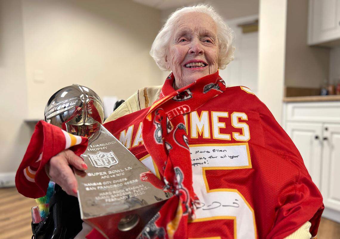 Mary Ellen Purucker, 104 years old, dons an autographed jersey from Chiefs quarterback Patrick Mahomes and holds a replica of the Vince Lombardi Trophy from the team’s Super Bowl win in 2020.