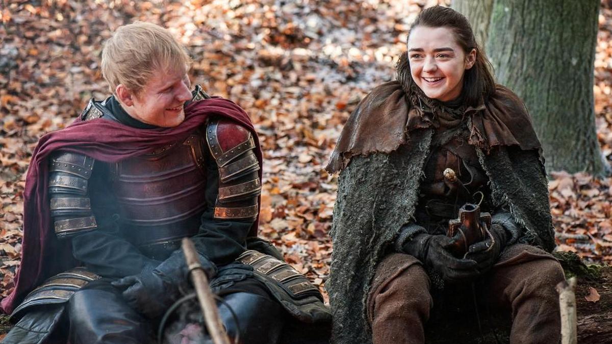 This image released by HBO shows Ed Sheeran, left, and Maisie Williams in a scene from "Game of Thrones." Sheeran appeared as a Lannister soldier leading a group in song in the season premiere of the hit HBO fantasy drama, which debuted on the premium cable channel Sunday night.