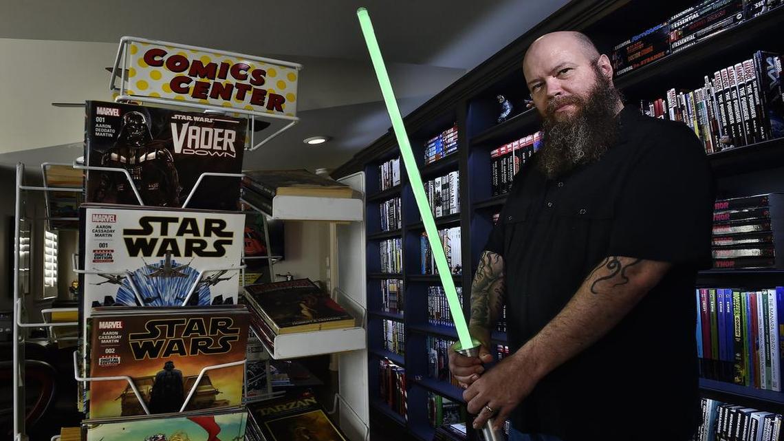 Jason Aaron is the writer of the Star Wars comic book, which ranks in the top five best-sellers with each monthly issue. His story takes up after the Death Star was destroyed in the very first Star Wars movie, before the events of “The Empire Strikes Back.” Aaron holds his collectible light saber near a stand of comic books he writes for.