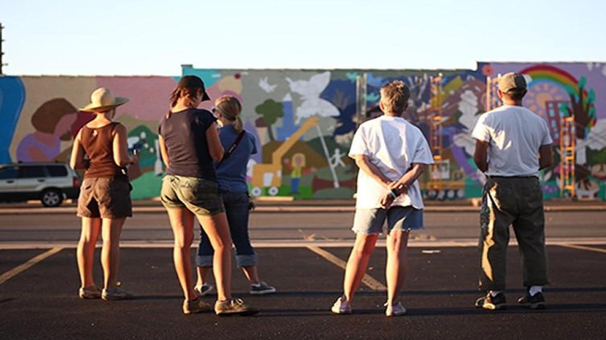 Design team members take a step back to get some perspective on the wall in Joplin, Mo. The town is one of four featured in the documentary “Called to Walls.”