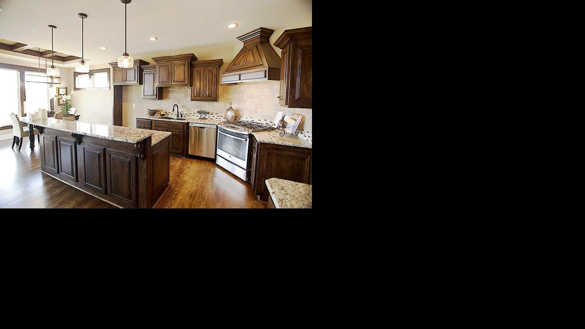 
The kitchen of this home in Heatherglen features custom raised-panel maple cabinets, granite counter tops, charging center and an island with pull-out microwave drawer.
