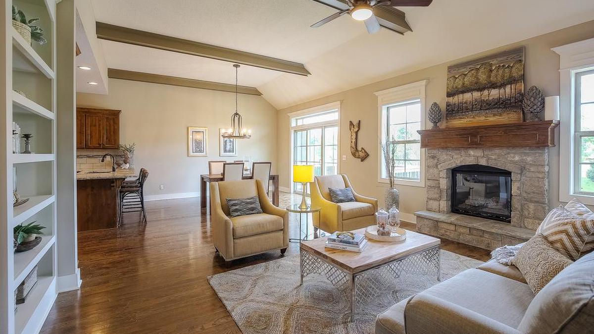 
This Coventry floor plan boasts wood beam ceilings, stone fireplace with hearth and a built- in bookshelf which complements the custom knotty alder cabinets and granite counter tops in the kitchen.

