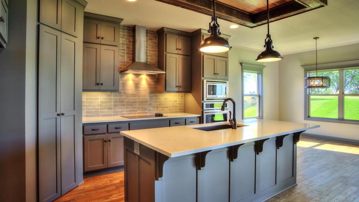 The Brookline is a spacious 1.5 story by SAB Construction; the contemporary farmhouse kitchen enhances this open plan. The master on the main and three bedrooms plus a loft upstairs make this the perfect family home.