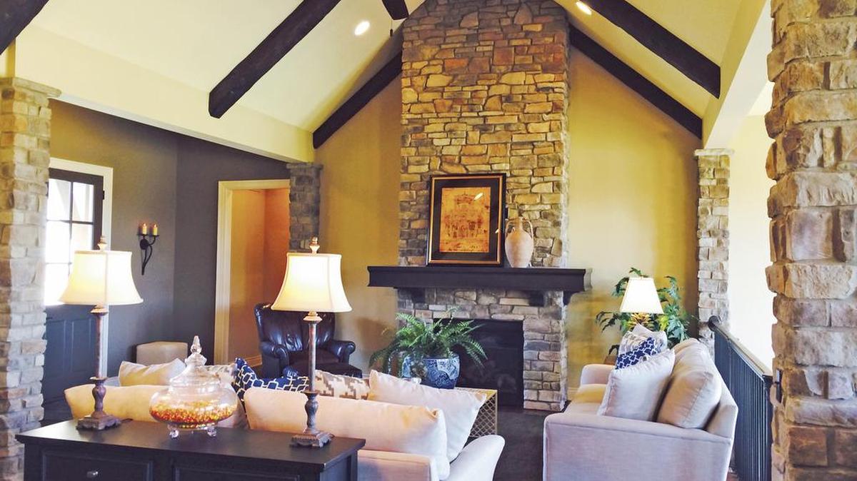 
Stone columns, soaring vaulted beam ceilings and a stacked stone fireplace are featured in the open concept Vail Valley Reverse 1
1/2-story floor plan by Dan Smith Homes Building Co.

