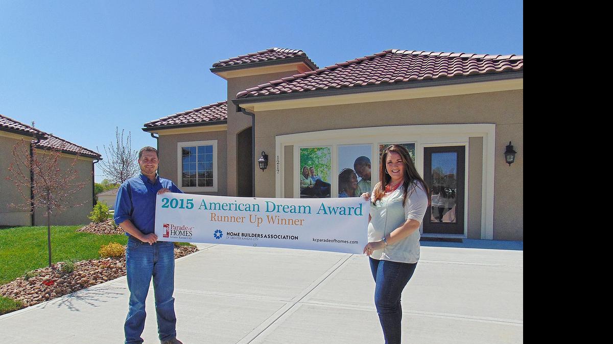 
Shane Davidson, project manager for the Villas of Parkwood with Summit Custom Homes and Danielle Sapienza, community manager for the Villas of Parkwood with The Rob Ellerman Team of ReeceNichols unveil the banner in front of the model home that won the First Runner-Up American Dream Award.
