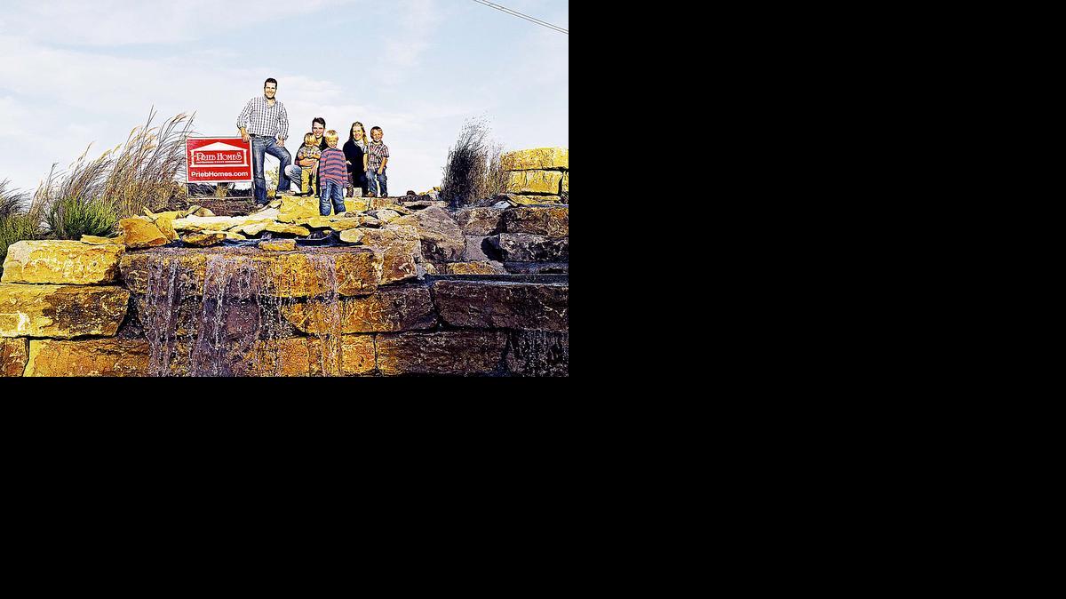 
Greg Prieb II, president of Prieb Homes, with the Brown family, Brampton West residents, at the community water fall.
