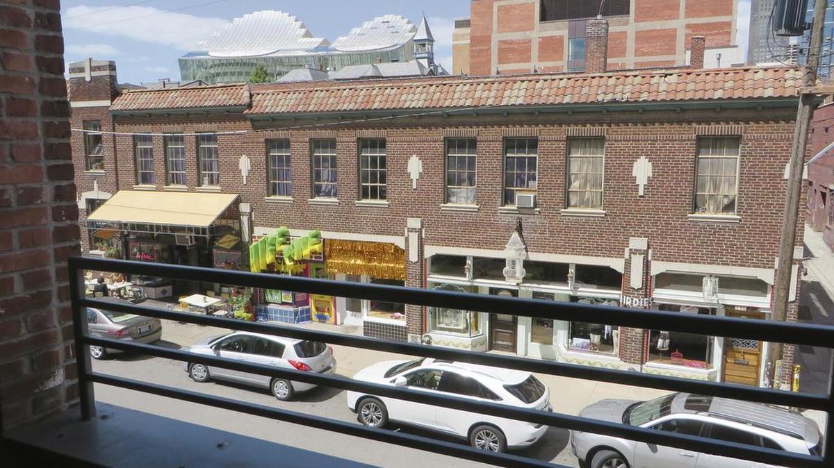 The balcony from Unit 205 in W Lofts, listed by Boveri Realty Group, offers views of 18th Street and the vibrant life in the neighborhood.