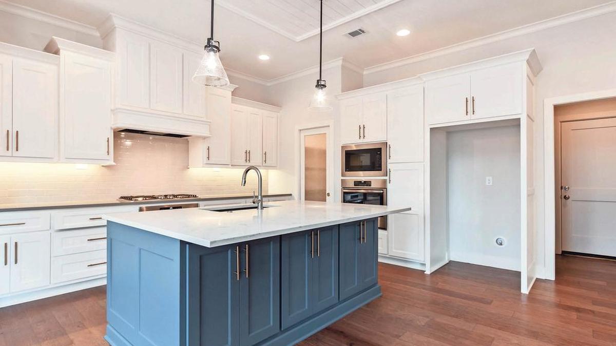 Custom cabinetry, quartz countertops and hardwood floors are among the luxurious kitchen finishes offered in Covington Creek’s Alexander reverse story and a half plan.