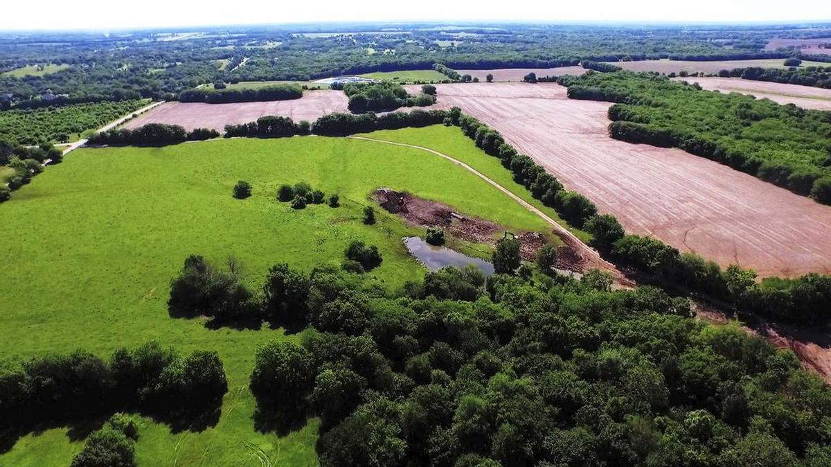 This aerial photograph illustrates Sundance Ridge's breathtaking terrain, which is marked by rolling acreage, winding creeks, and mature trees. Darol Rodrock proudly believes it’s “absolutely the most beautiful piece of ground in Overland Park. Nothing compares.”