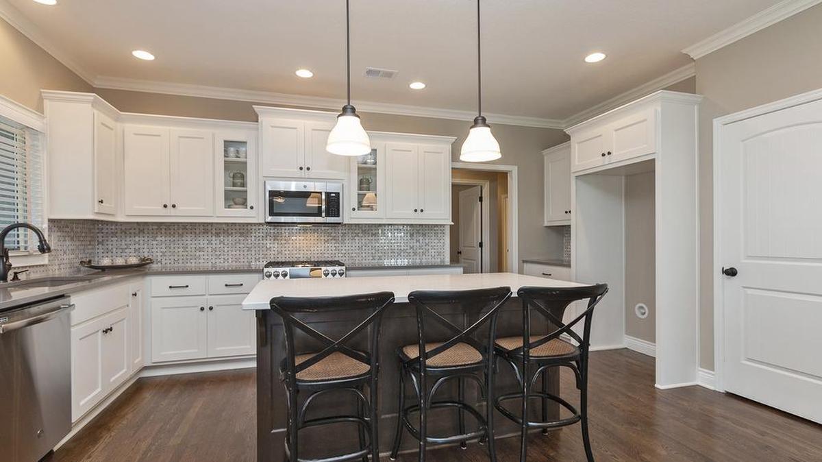 Custom cabinetry, granite countertops and hardwood floors are among the luxurious kitchen finishes offered in the new Ensley III ranch plan at Covington Court.