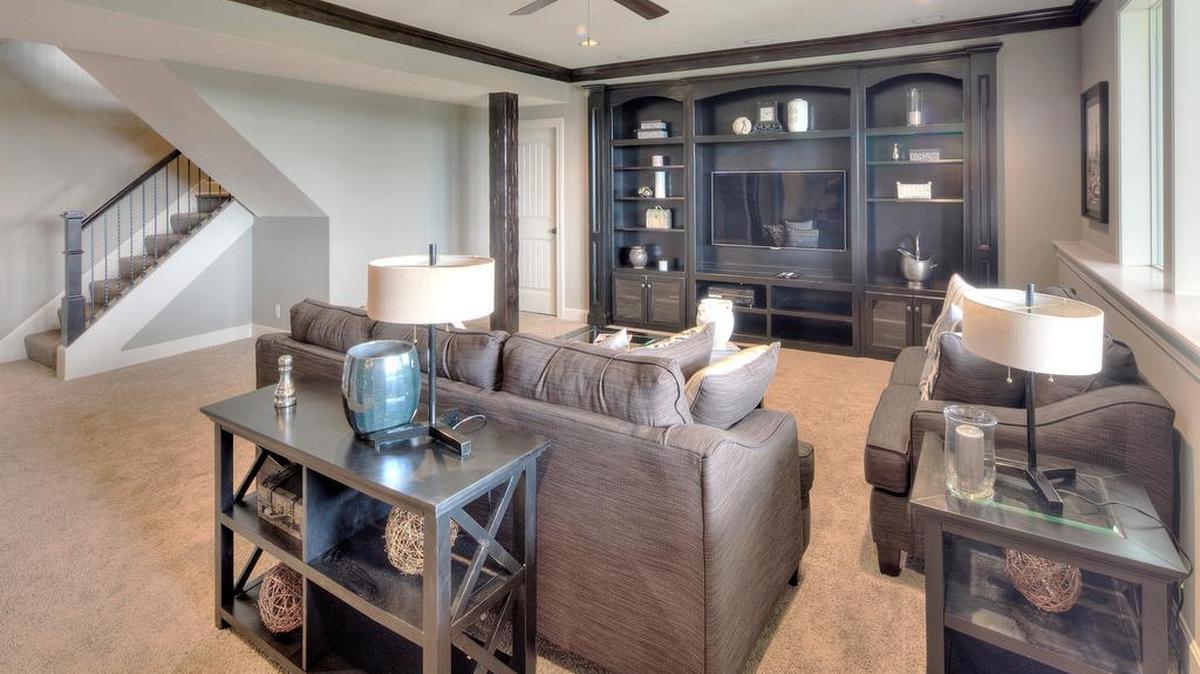 This custom built-in entertainment center is featured in the large finished basement with custom beams and stone arches in the Augusta 1.5 story at 12101 W. 164th St., in Johnson County.