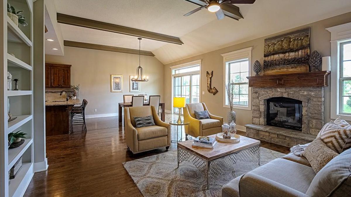 Leabrooke Town Manor’s Coventry floor plan boasts a wood treatment ceiling, stone fireplace with hearth, custom cabinets and granite countertops in the kitchen.