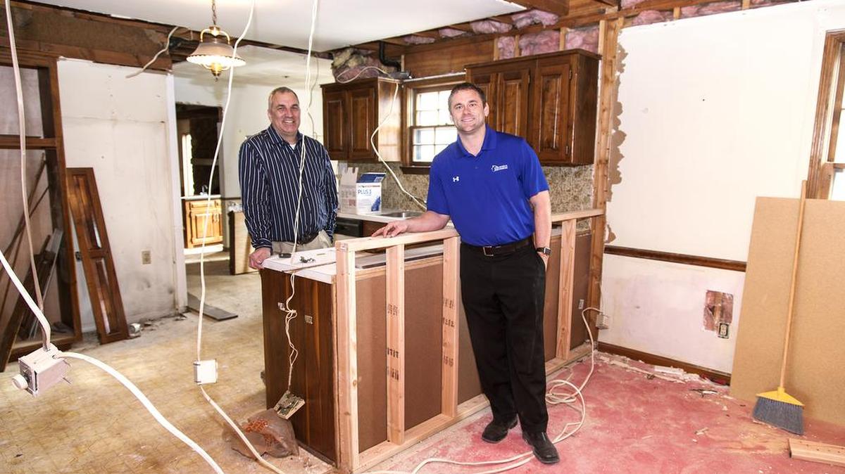 Ernie Bittner, left, who values houses, and Chad Lower, manager of House Buyers KC, check the progress on a house purchased by House Buyers KC that is being renovated.