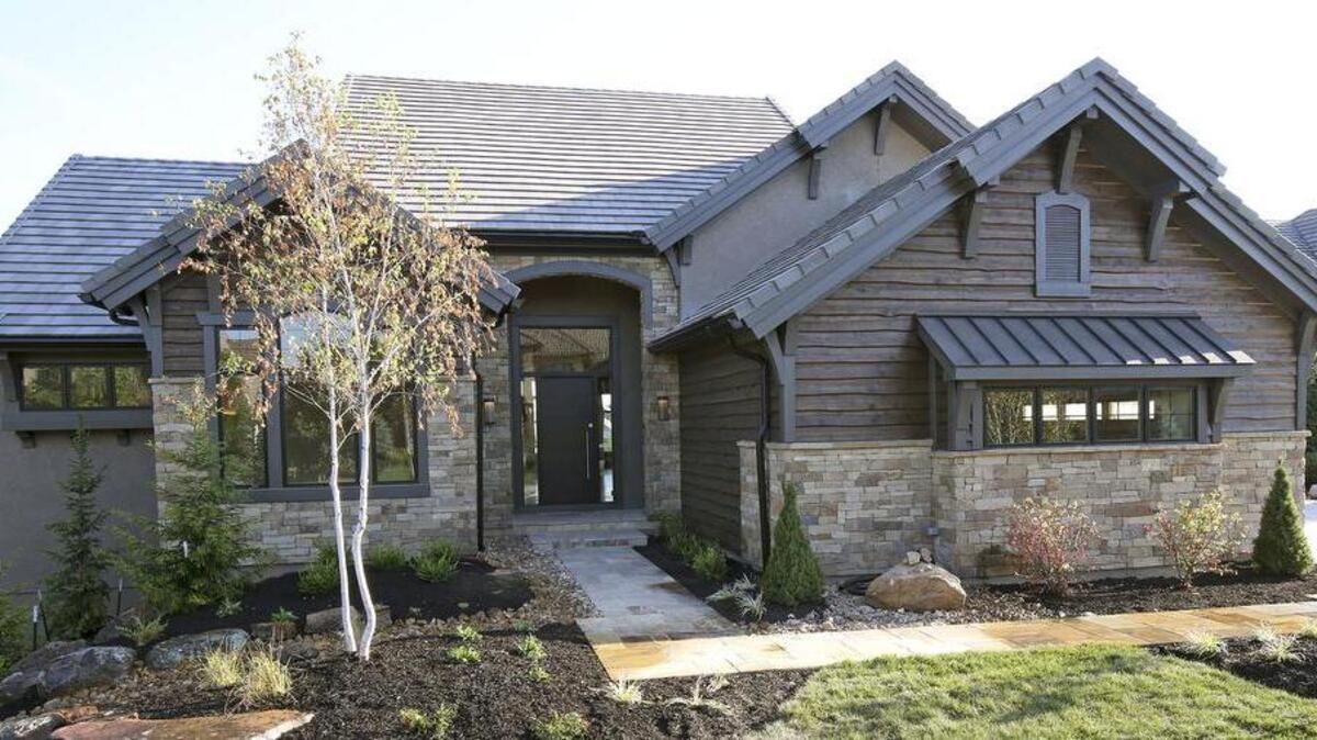 
The distinctive exterior of the custom Telluride in Rodrock Homes’ Summerwood Estates boasts a flagstone entry, wavy lap cedar siding, native stone and striking architecture reminiscent of a Colorado lodge, creating a modern-mountain inspired ambiance. 
