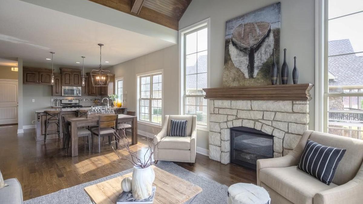 The Mayfair floor plan has a beautiful stone fireplace flanked by two stunning floor-to-ceiling windows that provide an abundance of natural light. The wood treatment on the ceiling complements the hardwood floors and custom cabinetry.