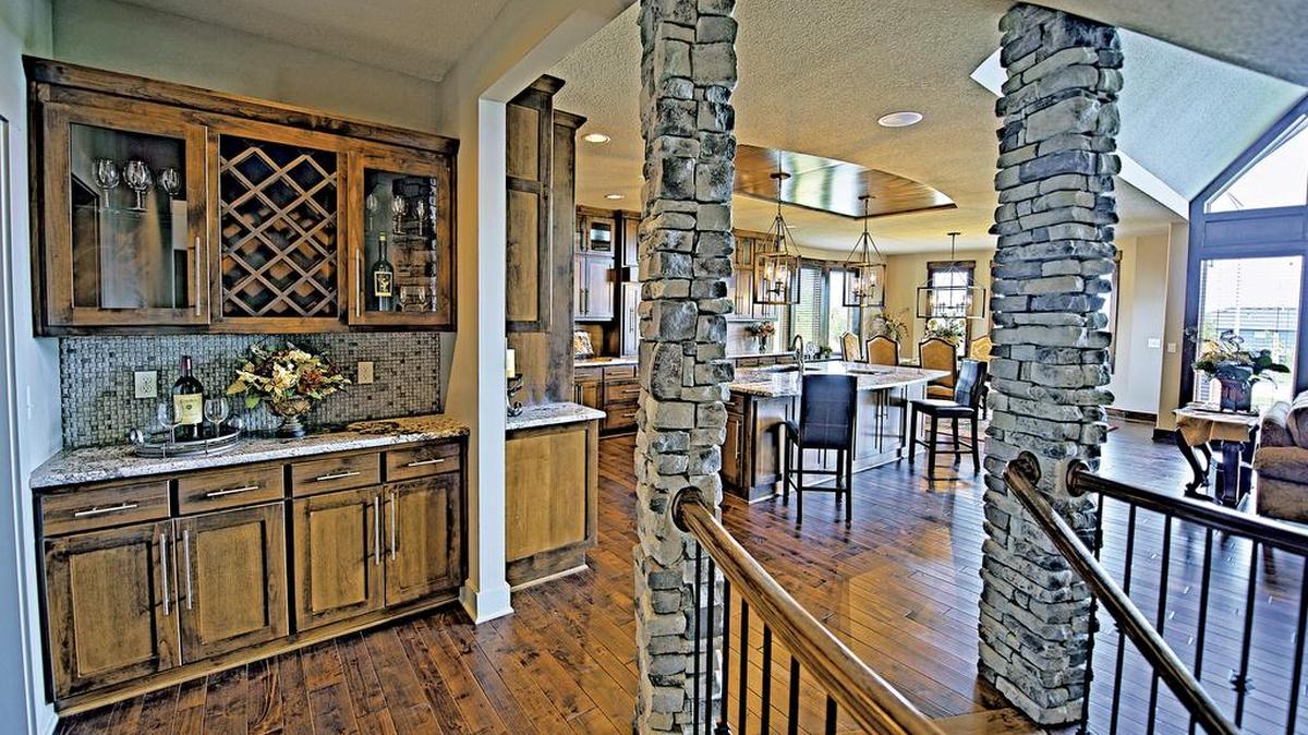 Among the move-in ready homes is a 1 ½-story rustic chalet, styled by Tabernacle Homes. It includes a Great Room with vaulted exposed truss/beam ceiling, a stone fireplace, and a wall of windows overlooking the woods.