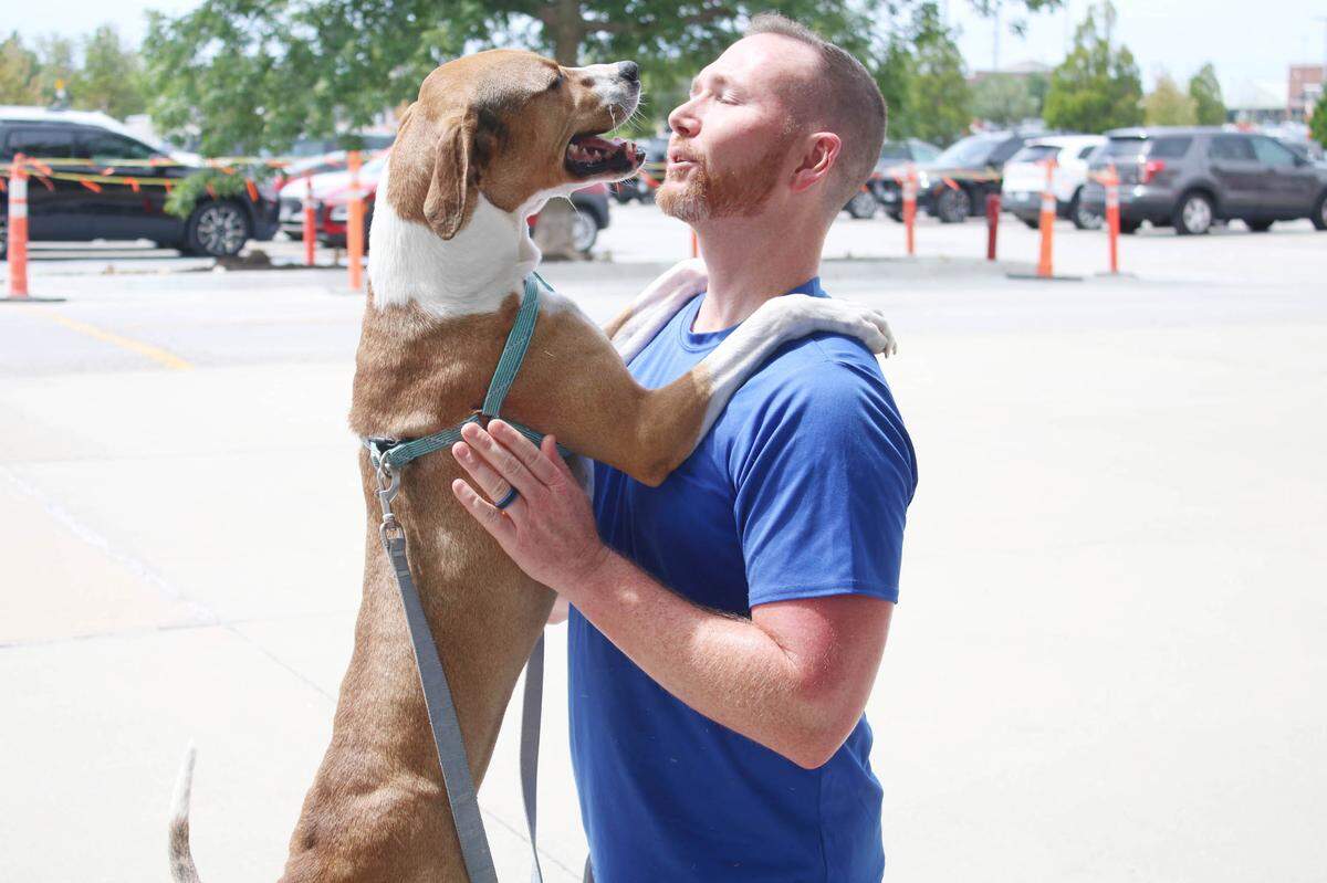Furry Kids Refuge volunteer Travis Kramer of Lee’s Summit gets a big hello from Maple at the weekly adoption event at Petco in Lee’s Summit.