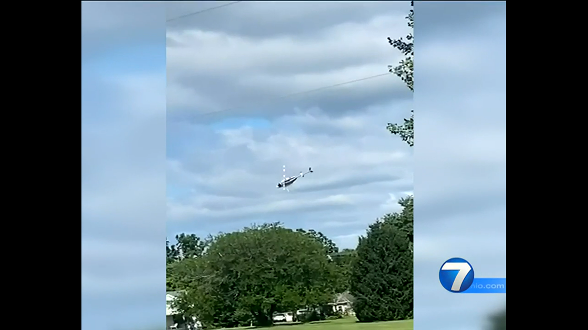 A helicopter hit power lines and then crashed, killing the pilot and causing car crashes on a nearby highway, Ohio officials said.