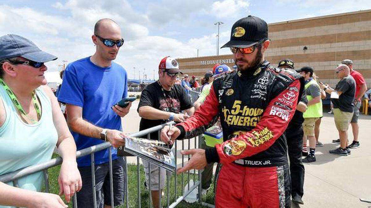 NASCAR driver Martin Truex Jr. (right) signed autographs during a May practice at Kansas Speedway in Kansas City, Kan.