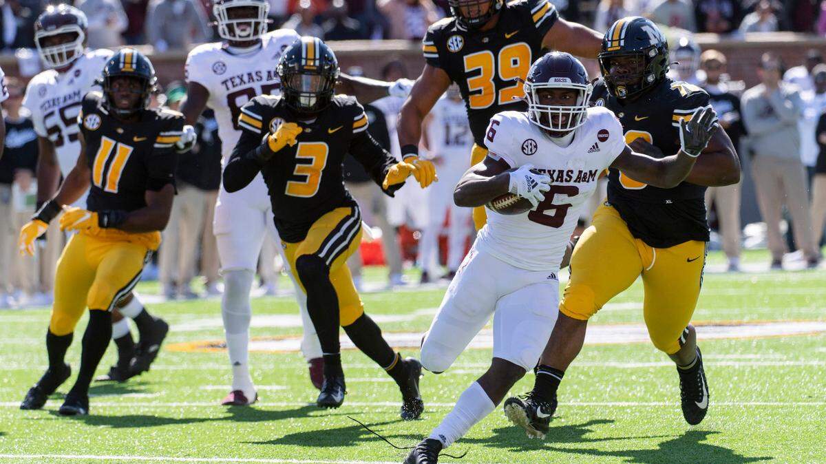 Texas A&M running back Devon Achane, right runs past Missouri’s Devin Nicholson (11), Martez Manuel (3), Chris Turner (39) and Kobie Whiteside during the first quarter of an NCAA college football game Saturday, Oct. 16, 2021, in Columbia, Mo. (AP Photo/L.G. Patterson)